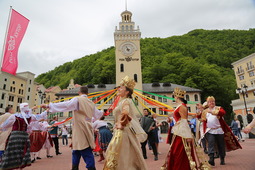 Участники и гости "Факела" вращают символическое "колесо удачи" на площади фестивального "Роза Хутора"